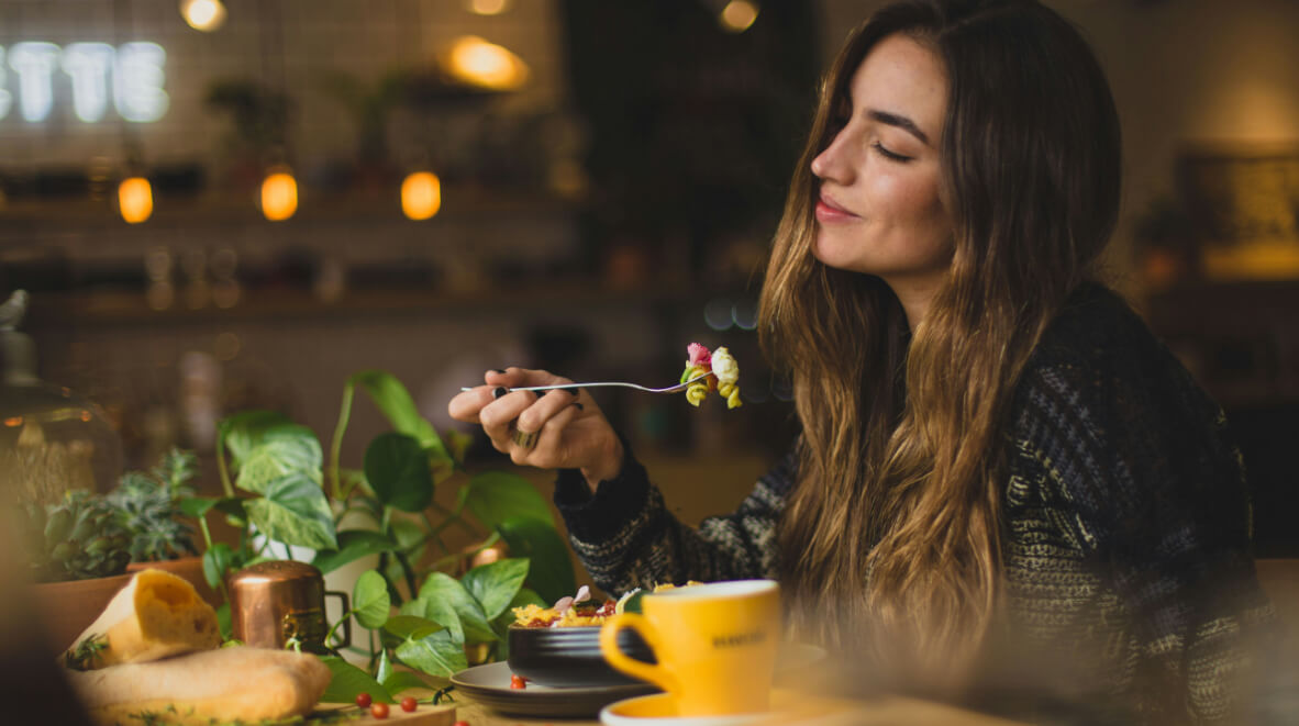Mujer sosteniendo tenedor en una mesa