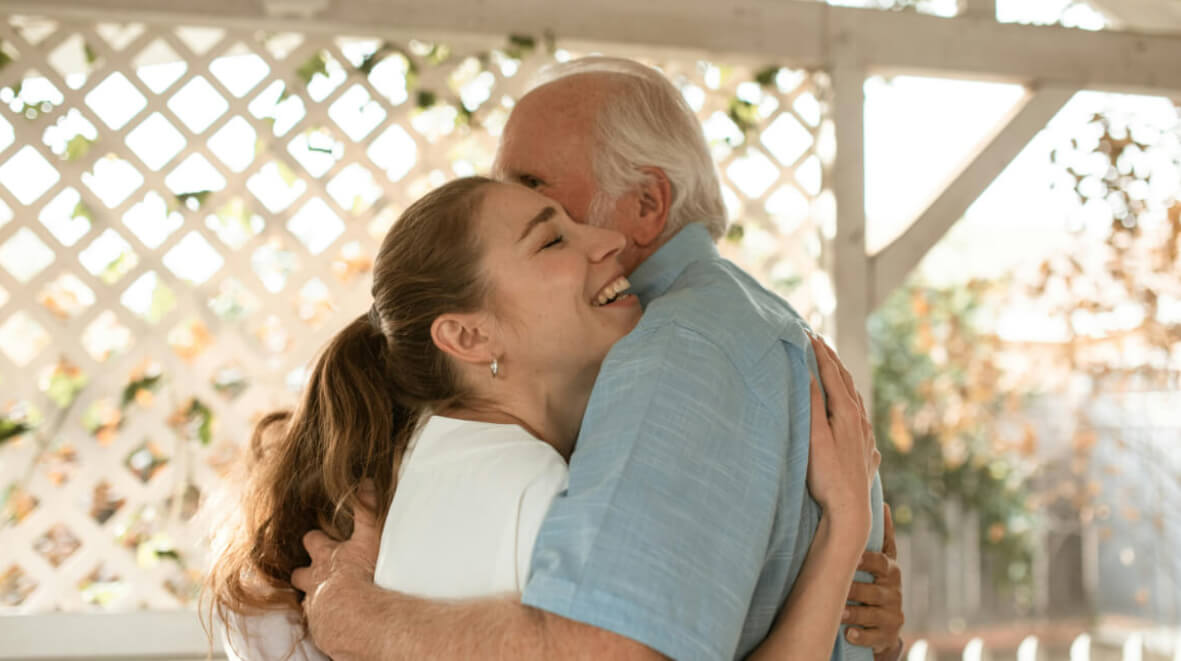 Hija abrazando a su padre anciano